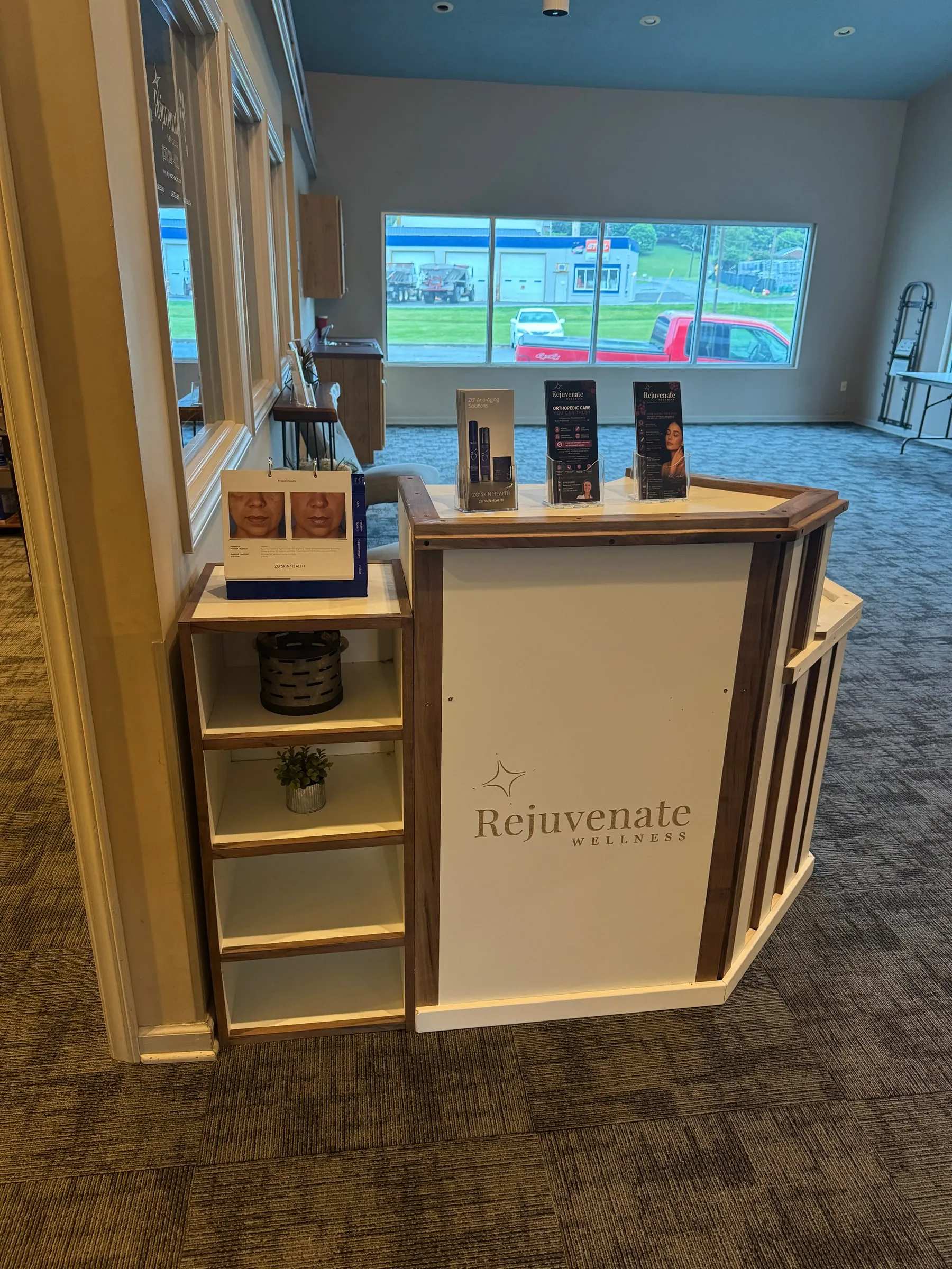 Front reception desk at Rejuvenate Wellness featuring branded signage and a window-lit lobby